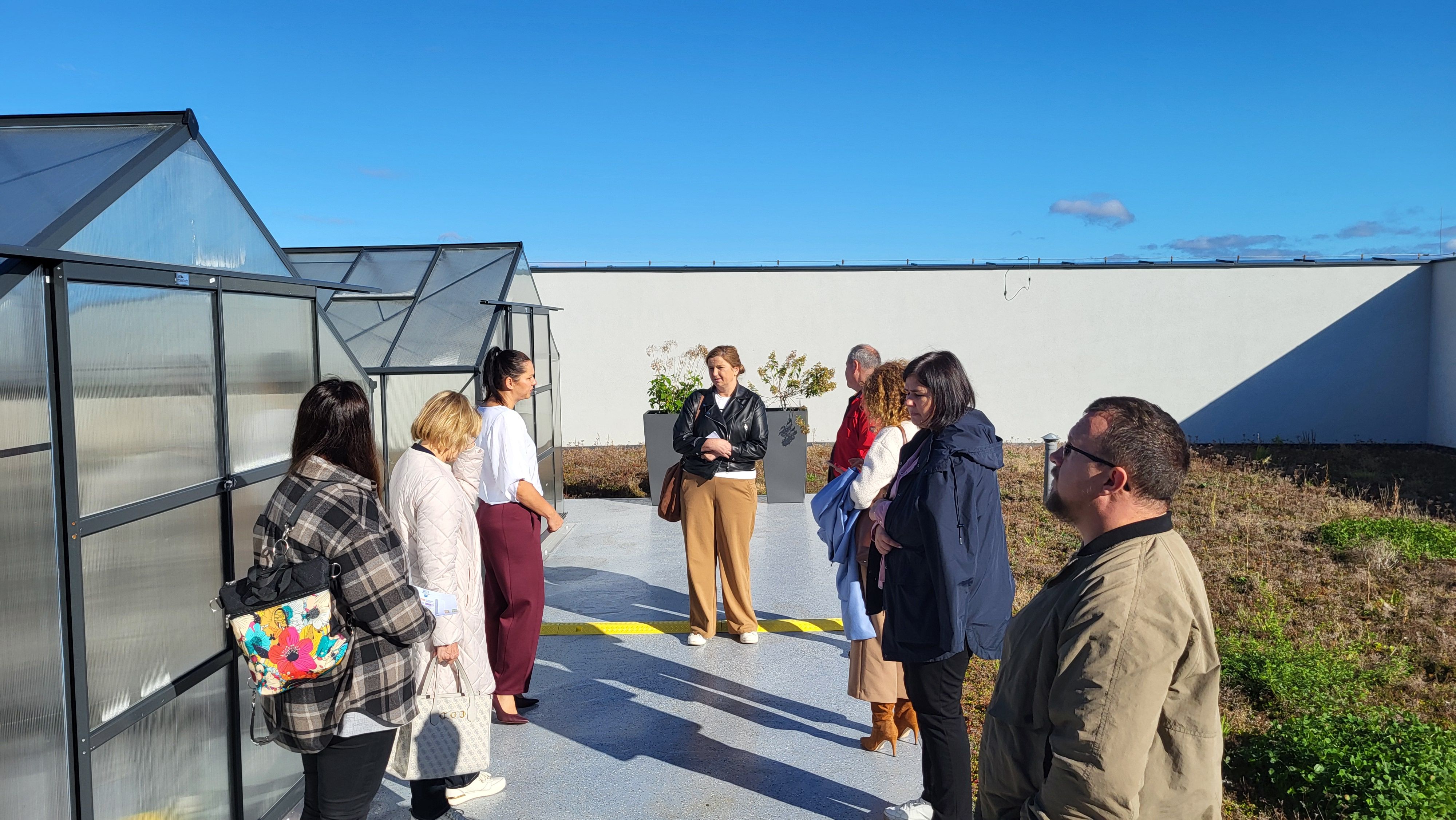 Wspólne spotkanie n dachu szkoły z widokiem na szklarnie.